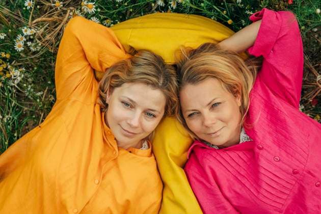 Creative Highlights Symbolfotos Happy sisters lying together on yellow bean bag model released, Symbolfoto, VSNF02194