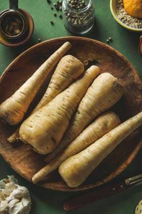 Raw parsnip vegetables on wooden plate , top view ,model released, Symbolfoto