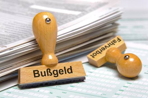 Bußgeld Ein Holzstempel ist beschriftet mit dem Aufdruck: Bußgeld