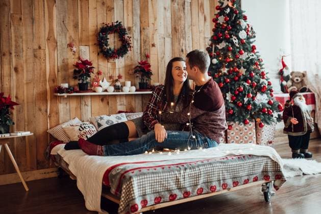 a guy and a girl celebrate the new year togetherin a warm atmosphere and give each other gifts ,model released, Symbolfoto