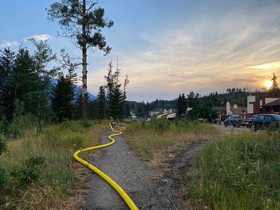 July 25, 2024, , Alberta, Canada: Water hoses are being used to help protect structures in . Wildfires have spread through , causing significant loss within the local town, according to park officials. More than 25,000 people were told to evacuate the area earlier this week, officials said. Jasper National Park Canada  - ZUMA 20240725_new_z03__035 Copyright: xJasperxNationalxParkx