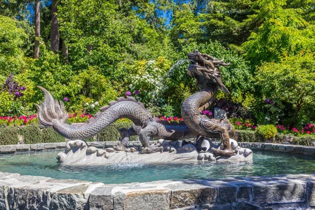 Butchart Gardens at Victoria, Vancouver Island, Canada in summer. View of a fountain and staute with flowers and trees of the historic garden. ,model released, Symbolfoto