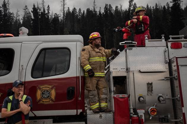 July 26, 2024, Jasper, Ab, CANADA: Firefighters stand by as Alberta Premier Danielle Smith arrives to survey the scene in Jasper, Alta., on Friday, July 26, 2024. Wildfires encroaching into the townsite of Jasper forced an evacuation of the national park and have destroyed over 300 of the town s approximately 1100 structures, mainly impacting residential areas. Jasper CANADA  - ZUMAc35_ 20240726_zaf_c35_129 Copyright: xAmberxBrackenx
