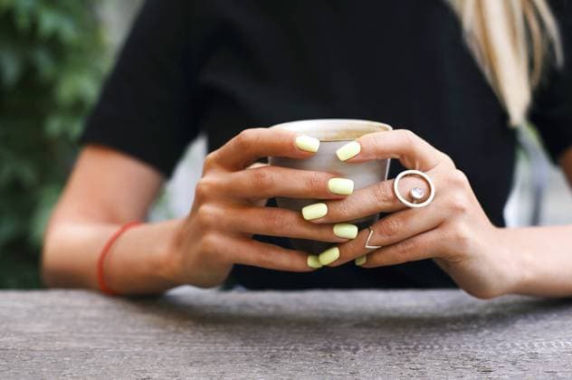 Creative Highlights Symbolbilder Mug in the hands of a young woman wearing silver rings. Girl holding a Cup of coffee in a cafe. Coffee break, Breakfast. Close up Copyright: imageBROKER DashaxPetrenko ibxiqx10537224.jpg ,model released, Symbolfoto ,property released