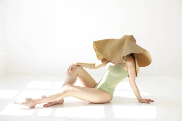Creative Highlights Symbolbilder Side view of anonymous slim young woman in stylish swimsuit and large summer hat resting on white background Copyright: imageBROKER DashaxPetrenko ibxiqx10540727.jpg ,model released, Symbolfoto ,property released