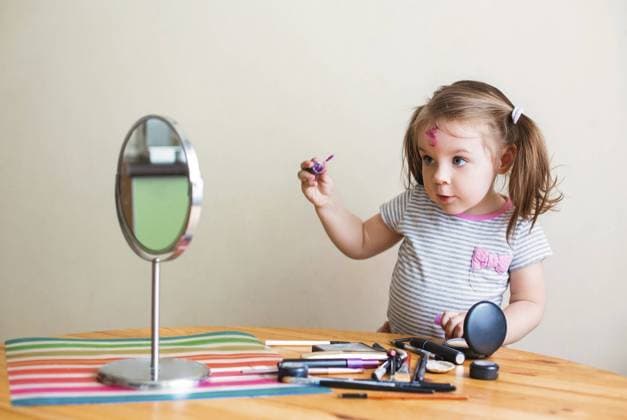Creative Highlights Symbolbilder Adorable little child with dirty face playing with cosmetics and doing makeup while looking in mirror Copyright: imageBROKER DashaxPetrenko ibxiqx10541070.jpg ,model released, Symbolfoto ,property released