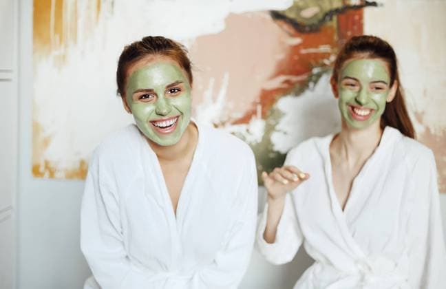 Creative Highlights Symbolbilder Delighted female friends in bathrobes and with green clay masks relaxing at home while doing daily skincare treatment and laughing Copyright: imageBROKER DashaxPetrenko ibxiqx10541255.jpg ,model released, Symbolfoto ,property released