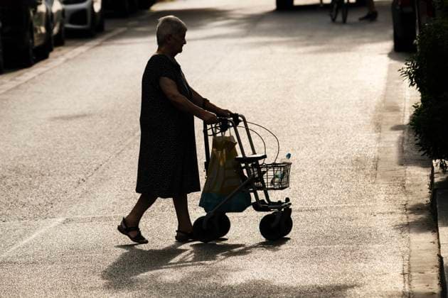 IMAGO Creative, Jahreszeit Sommer, Hitze alte Frau mit Rollator bei Sommerhitze in der Stadt unterwegs, Juli 2024 Deutschland, München, Juli 2024, alte Frau mit Rollator in der Hitze unterwegs, bei der Sommerhitze besteht vor allem für ältere Menschen die Gefahr der Dehydrierung, Seniorin hat Wasserflasche mitgenommen, starkes Sonnenlicht, Gegenlicht, Silhouette, Symbolfoto Rente, Rentner, Senioren, Leben im Alter, eingeschränkte Mobilität, Bewegung, Selbstständigkeit im Alter, *** old woman with rollator walking in the city in the summer heat, July 2024 Germany, Munich, July 2024, old woman with rollator walking in the heat, in the summer heat there is a risk of dehydration, especially for older people, senior citizen has taken a water bottle with her, strong sunlight, back