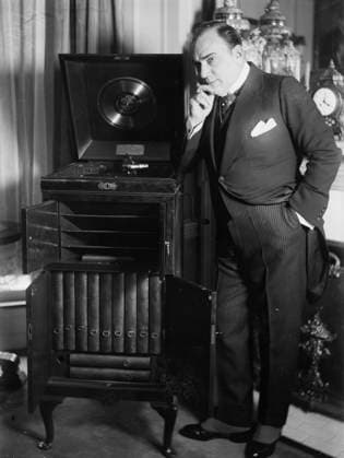 RECORD DATE NOT STATED Enrico Caruso with phonograph, between 1918 and c1920. Shows opera singer Enrico Caruso (1873-1921) with a customized Victrola phonograph which was a wedding gift in 1918. Copyright:xHeritagexArt HeritagexImagesxBainxNewsxServicex IMAGO, ! ACHTUNG: AUFNAHMEDATUM GESCHÄTZT!  Copyright:HeritagexArt HeritagexImagesxBainxNewsxServicex IMAGO