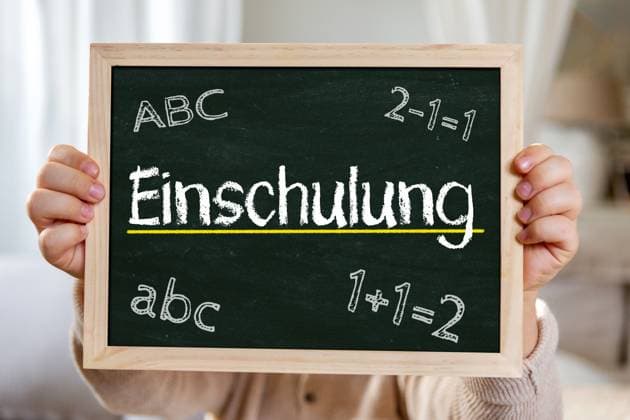 2 August 2024: School enrollment. Symbolic image of children starting school, moving from kindergarten to school. Child holding board with inscription: School enrollment. PHOTOMONTAGE *** Einschulung. Symbolbild Einschulung von Kindern, wechsel vom Kindergarten in die Schule. Kind hält Tafel mit Aufschrift: Einschulung. FOTOMONTAGE