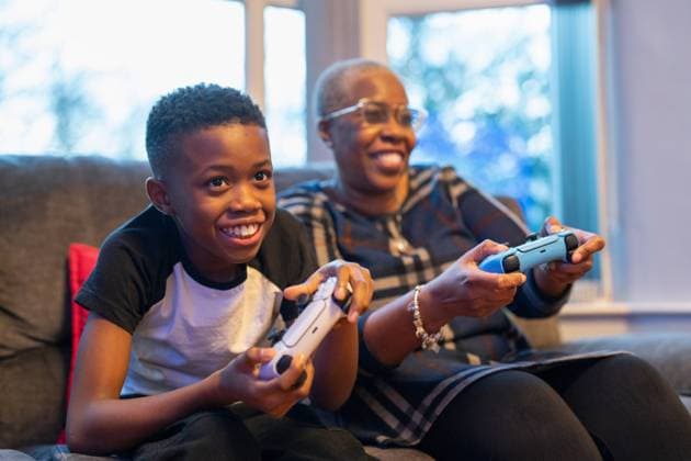Grandmother and grandson playing video game at home model released Copyright: xCulturaxCreativex
