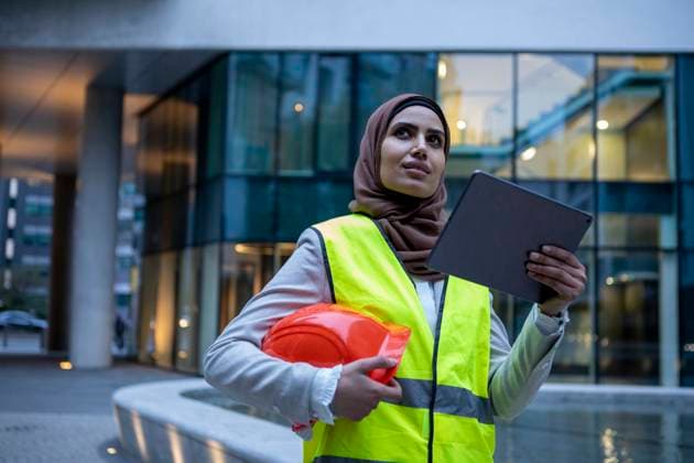 UK, London, Female engineer in hijab holding tablet on front of modern building model released Copyright: xCulturaxCreativex