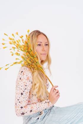 Creative Highlights Symbolbilder Woman holding yellow flowers, wearing star-patterned blouse and United States, California, Los Angeles R_FBJQ240801-1499815-01 ,model released, Symbolfoto
