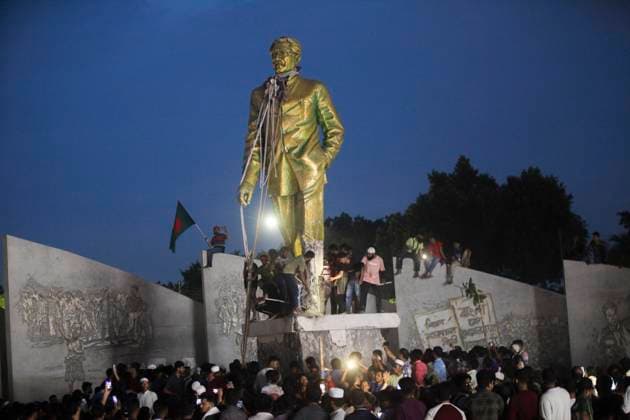 August 5, 2024, Dhaka, Dhaka, Bangladesh: Anti-government protestors climbs atop a statue of Sheikh Mujibur Rahman, Bangladesh s founding father and parent of the country s ousted Prime Minister Sheikh Hasina, in Dhaka on August 5, 2024. Bangladeshi Prime Minister Sheikh Hasina s 15-year rule ended on August 5, as she fled after more than a month of deadly protests as the military announced it would form an interim government. Dhaka Bangladesh - ZUMAj163 20240805_zip_j163_005 Copyright: xAbuxSufianxJewelx
