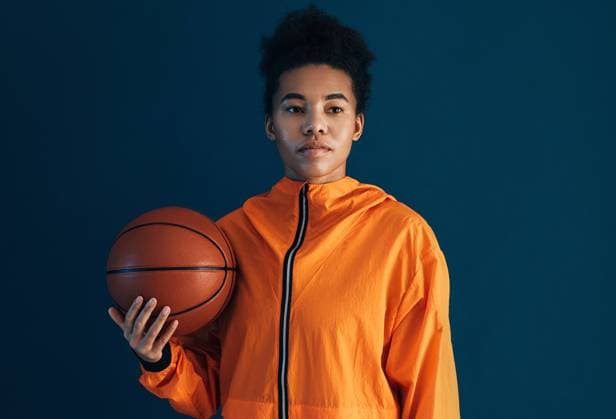 Creative Highlights Symbolbilder Portrait of a confident woman with basketball over blue backdrop looking away Portrait of a confident woman with basketball over blue backdrop looking away Copyright: xxArtemxVarnitsinx