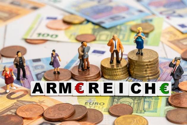 9 August 2024: Miniature figures stand on euro coins and bills, with the words rich and poor symbolizing economic inequality. PHOTOMONTAGE *** Miniaturfiguren stehen auf Euro-Münzen und -Scheinen, wobei der Schriftzug Arm und Reich die wirtschaftliche Ungleichheit symbolisiert. FOTOMONTAGE