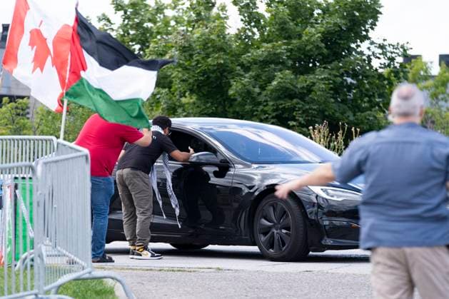 August 10, 2024, Brampton, On, Canada: Pro Palestinian protesters, left, yell at drivers attending a Liberal Party Fundraising event in anticipation of the arrival of Prime Minister Justin Trudeau (not pictured), as a police officer directs traffic, right, in Brampton, Ont., Saturday, August 10, 2024. Brampton Canada  - ZUMAc35_ 20240810_zaf_c35_172 Copyright: xArlynxMcadoreyx