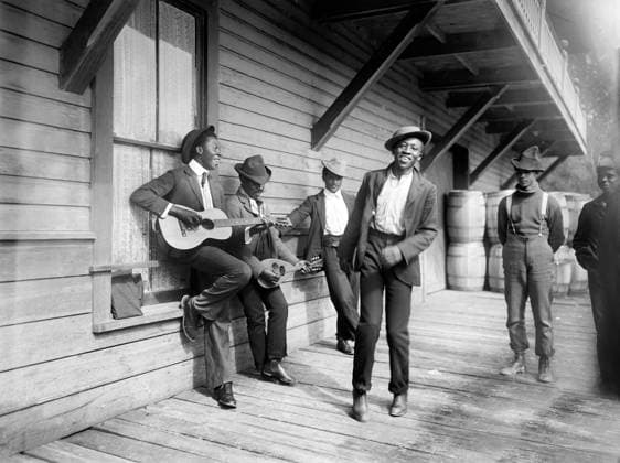 Group of men playing music and dancing on porch, Waiting for the Sunday Boat , William Henry Jackson for Detroit Publishing Company, 1902  Copyright: xCircaxImagesx ghi-circa03731