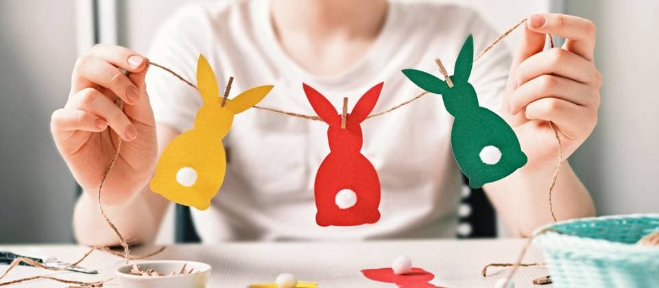 Banner with DIY Easter home decor. Happy boy make garland of colored paper, twine and pom-poms. Selective focus Banner with DIY Easter home decor. Happy boy make garland of colored paper, twine and pom-poms. Selective focus. Copyright: xZoonar.com ELENAxNAZAROVAx 21740178