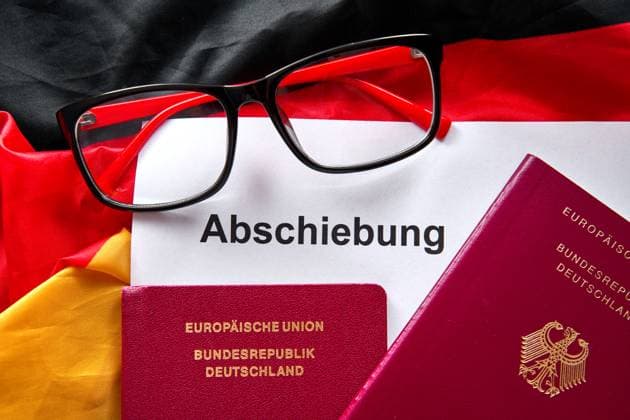 13 August 2024: A document with the title Abschiebung lies next to German passports and a pair of glasses on the flag of the Federal Republic of Germany *** Ein Dokument mit dem Titel Abschiebung liegt neben deutschen Reisepässen und einer Brille auf der Flagge der Bundesrepublik Deutschland