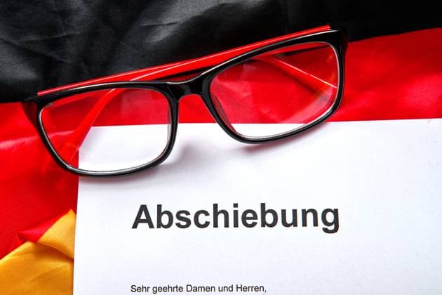 13 August 2024: A document with the title Abschiebung lies next to German passports and a pair of glasses on the flag of the Federal Republic of Germany *** Ein Dokument mit dem Titel Abschiebung liegt neben deutschen Reisepässen und einer Brille auf der Flagge der Bundesrepublik Deutschland