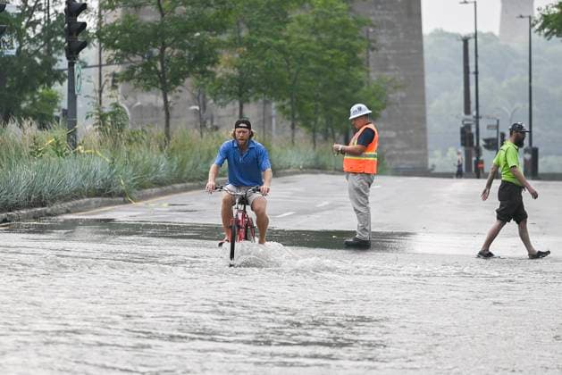 Kanada, Rohbruch sorgt für Überschwemmung in Montreal August 16, 2024, Montreal, Pq, Canada: A person bikes across a flooded street due to a water main break in Montreal, Friday, August 16, 2024, causing flooding in several streets of the area. Montreal Canada  - ZUMAc35_ 20240816_zaf_c35_004 Copyright: xGrahamxHughesx