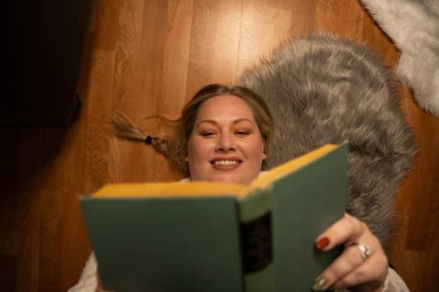 Woman lying on the floor, smiling while reading a book Waunakee, Wisconsin, United States R_SUKG2408058F-1462336-01 ,model released, Symbolfoto