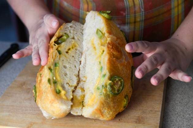 Hands holding a sliced jalapeno-topped bread loaf, showing the United States, Florida, Inverness R_YWQX240805A8-1499218-01 ,model released, Symbolfoto