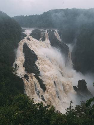 Creative Highlights World A waterfall with a misty, cloudy sky in the background Cairns, Queensland, Australia R_YBTM240805-1502231-01