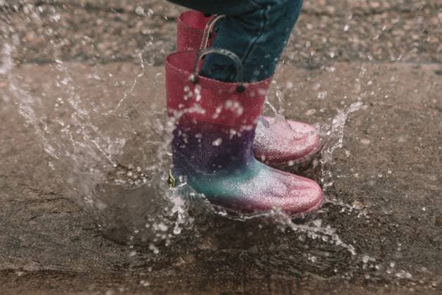 Splashing in a buddle in rainbow rainboots Cincinnati, Ohio, United States R_KRHE210921-832852-01 ,model released, Symbolfoto
