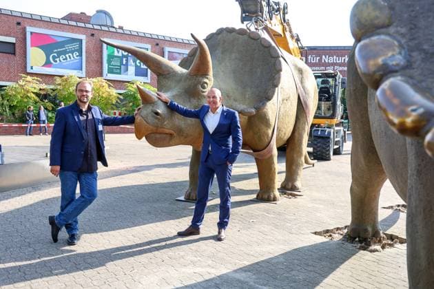 Wenn schwere Dinos fliegen - Modelle vor dem LWL-Museum für Naturkunde versetzt. Wahrzeichen des Museums kennzeichnen neuen Museumseingang. Das LWL-Museum für Naturkunde bekommt einen Anbau auf dem Museumsvorplatz. Dr. Georg Lunemann, Direktor des Landschaftsband Westfalen-Lippe (re.) und Dr. Jan Ole Kriegs, Museumsdirektor. Münster, Nordrhein-Westfalen, DEU, Deutschland, 22.08.2024