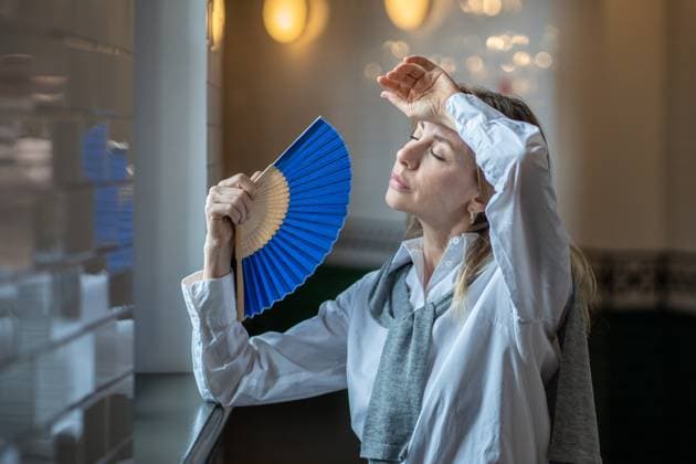IMAGO Creative, Jahreszeit Sommer, Hitze Woman suffering from heat stuffy air in office without air conditioning fanned herself with hand fan Woman, tired of stuffiness at work, suffering from heat or headache, sweltering stuffy air in an office without air conditioning, stepped out into hallway, fanning herself with paper fan. ,model released, Symbolfoto Copyright: xZoonar.com DmitriixMarchenkox 22051634 ,model released, Symbolfoto ,property released