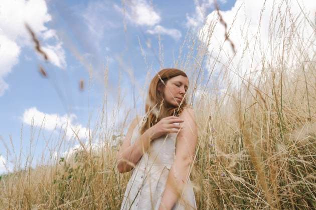 Creative Highlights Symbolbilder Woman standing with closed eyes in rural field model released, Symbolfoto, ASVF00113