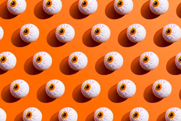 Pattern of rows of Halloween candy with eyeball wrapping against orange background, FLMF01115