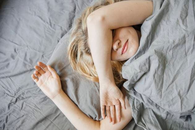Creative Highlights Symbolbilder Woman covering eyes with arm and sleeping in bed at home model released, Symbolfoto property released, KVBF00279