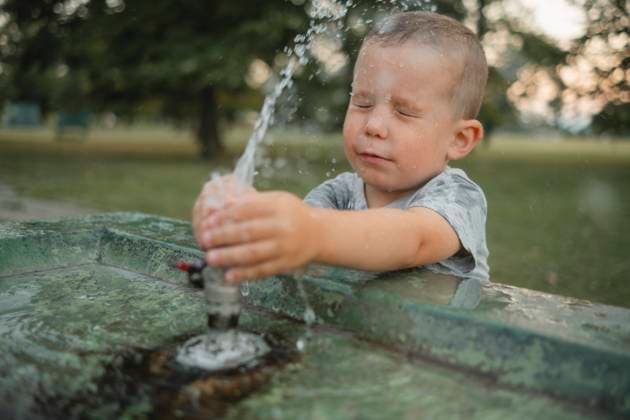 Creative Highlights Symbolbilder Boy playing with water at drinking fountain model released, Symbolfoto, KVBF00323
