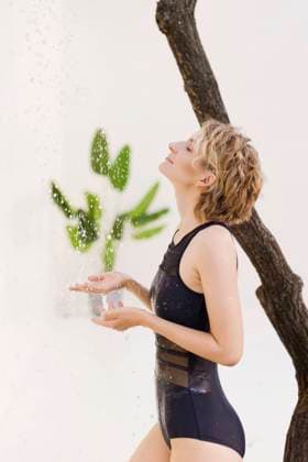 Creative Highlights Symbolbilder Woman with eyes closed enjoying shower at poolside model released, Symbolfoto property released, ONAF00970