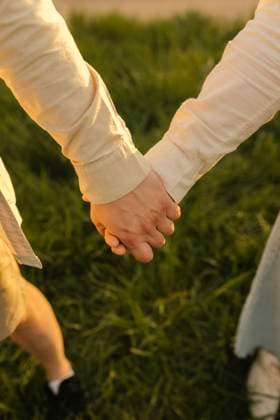 Creative Highlights Symbolbilder Man and woman holding hands at meadow model released, Symbolfoto, VIVF01369