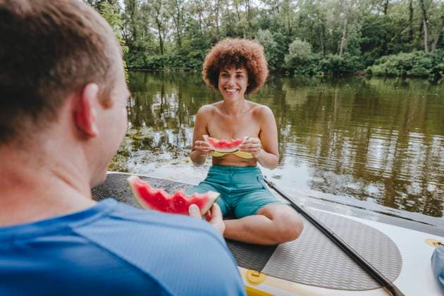 Creative Highlights Symbolbilder Smiling friends having watermelon on paddleboard in lake model released, Symbolfoto, YTF01038