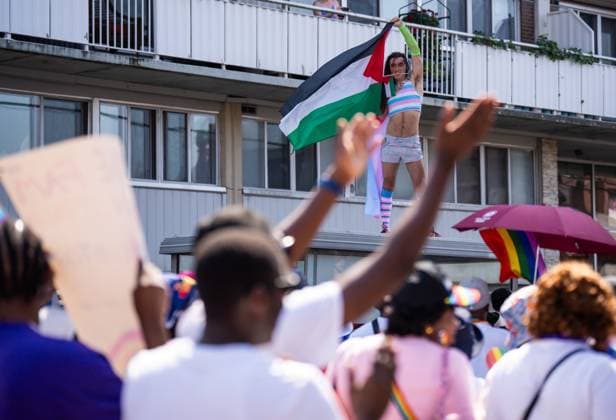 August 25, 2024, Ottawa, On, Canada: A spectator waves a Palestine flag while standing on top of a bus shelter during the Capital Pride Parade in Ottawa, on Sunday, August 25, 2024. Ottawa Canada  - ZUMAc35_ 20240825_zaf_c35_031 Copyright: xChrisxTanouyex