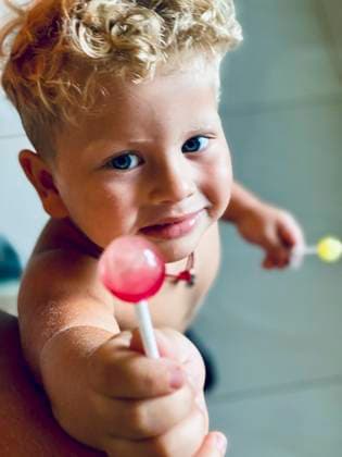 Creative Highlights Symbolbilder blonde curly boy sharing a candy on a stick Dnipro, Dnipropetrovsk Oblast, Ukraine R_PMDCMQ210915-830149-01 ,model released, Symbolfoto