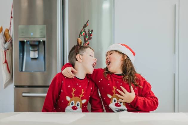 Creative Highlights Symbolbilder Two cheerful twins dressed in Christmas sweaters and hats laugh and enjoy themselves in a modern kitchen, capturing the spirit of Christmas togetherness Model Released HodeiUnzueta_ID23536_683519_010 Copyright: xHodeixUnzuetax