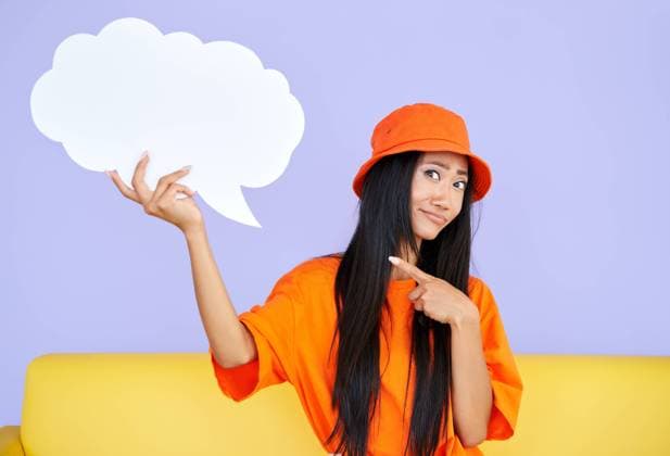 Creative Highlights Symbolbilder Junge Hipster Frau, die eine leere Sprechblase hält und mit dem Finger darauf zeigt und in die Kamera schaut Young hipster woman holding empty speech bubble pointing her finger on it and looking to camera Copyright: imageBROKER ViktorxGladkov ibxiqx09031312.jpg ,model released, Symbolfoto ,property released