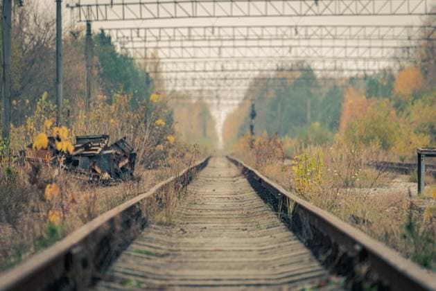 Leere, verlassene Zuggleise, die in den fernen Fluchtpunkt in Pripyat, Sperrzone von Tschernobyl, führen Empty abandoned train tracks leading into the distant vanishing point in Pripyat, Chernobyl Exclusion Zone Copyright: imageBROKER RobertxRuidl ibxiqx09186771.jpg