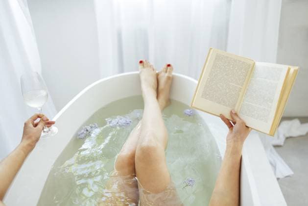 Rückenansicht der jungen brünetten Frau, die ein Buch liest und Weißwein im Bad mit Schaum und Kerzen trinkt Back view of the young brunette woman reading the book and drinking white wine in bath with foam and candles Copyright: imageBROKER DashaxPetrenko ibxiqx09199206.jpg ,model released, Symbolfoto ,property released