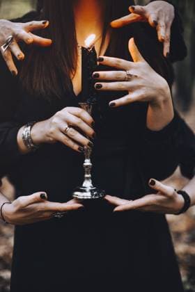 Mysteriöses Foto einer Hexe mit brennender Kerze, die von vielen Händen während eines magischen Rituals im dunklen Herbstwald berührt wird. Hexerei Konzept Mysterious photo of woman witch with burning candle being touched by many hands during magic ritual in dark autumn forest. Witchcraft concept Copyright: imageBROKER DashaxPetrenko ibxiqx09199235.jpg ,model released, Symbolfoto ,property released