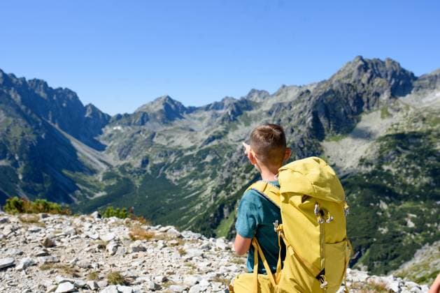 Boy on hike in autumn mountains. Kids spending summer break in nature. Rear view. Boy on hike in autumn mountains. Kids spending time, summer break in nature. Rear view. model released