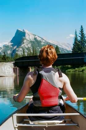 Creative Highlights Symbolbilder Person rowing a canoe on calm waters with a mountain backdrop Calgary, Alberta, Canada CR_ARUI24083087-1530179-01 ,model released, Symbolfoto
