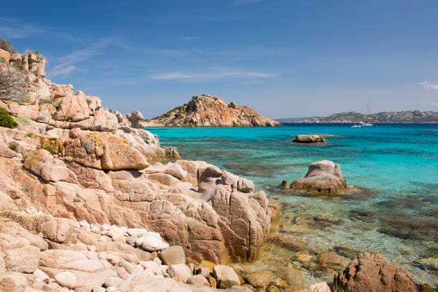 View from rocks across the clear turquoise waters of Cala Corsara to the pink granite headland of Punta Rossa Corsara, Spargi Island, La Maddalena Archipelago National Park, Sassari, Sardinia, Italy, Mediterranean, Europe Copyright: DavidxTomlinson 1310-384 RECORD DATE NOT STATED