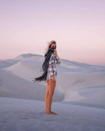 Creative Highlights Symbolbilder A young woman standing on sand dunes at sunset, with a scarf covering her face 25709174 ,model released, Symbolfoto RECORD DATE NOT STATED